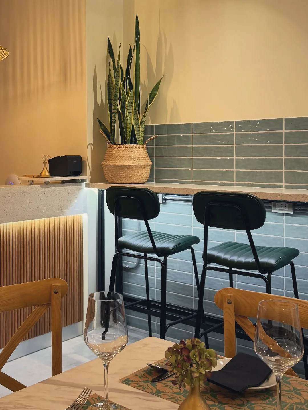 La barra con listones de madera, pisos altos, planta y lámpara de mimbre