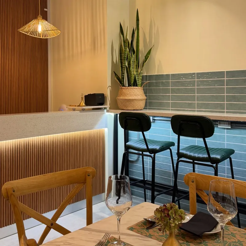 La barra con listones de madera, pisos altos, planta y lámpara de mimbre