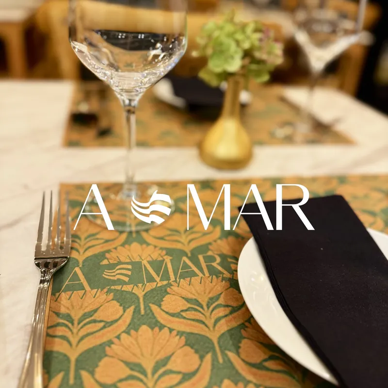 Individual estampado con el logotipo de A MAR, copa y florero dorado