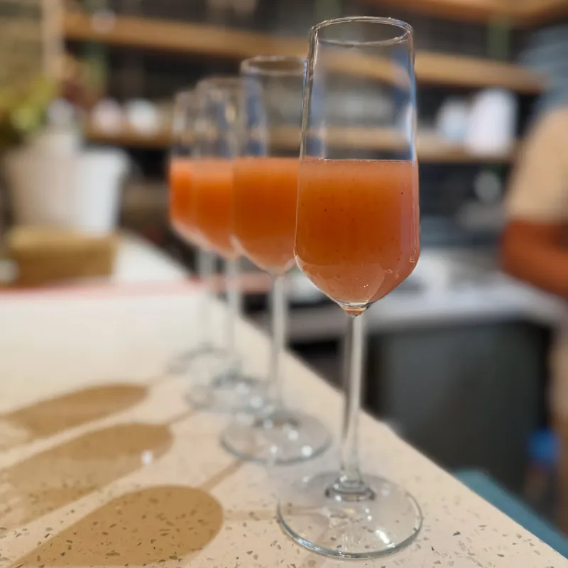 Cuatro copas de murta sour alineadas en la barra