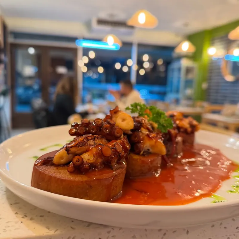 Pulpo y chapaleles (masa de papa chilota) a la chapa en salsa roja