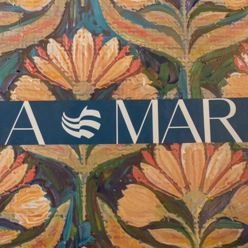 Textil floral pintado, cruzado por una franja azul con el logotipo de A MAR
